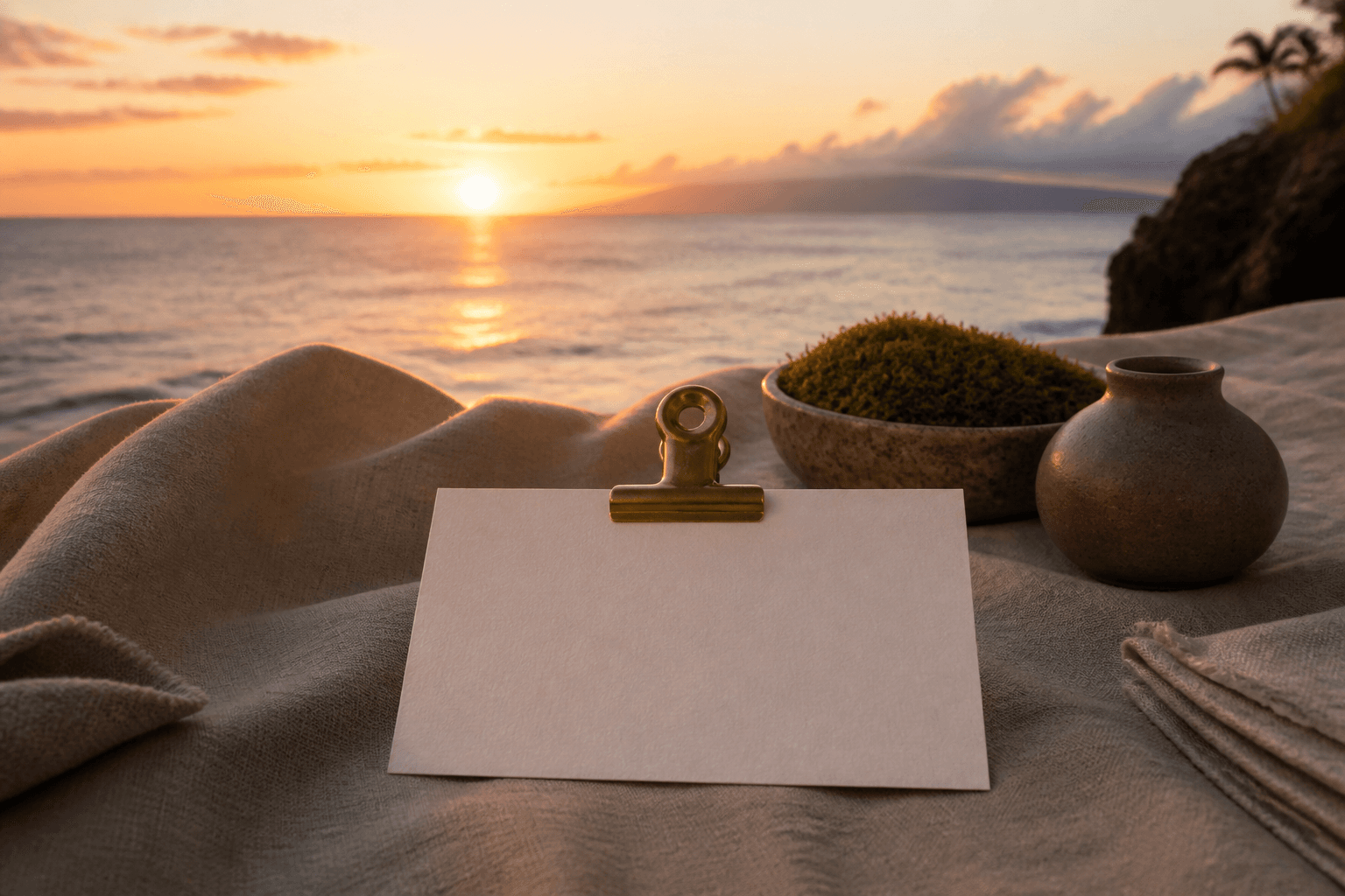 A blank unused ivory card under a brass clip on a Wailea lānai pass at west sunset.